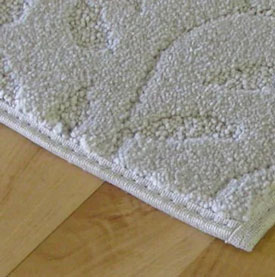 Professional carpet binding service showing finished carpet edge